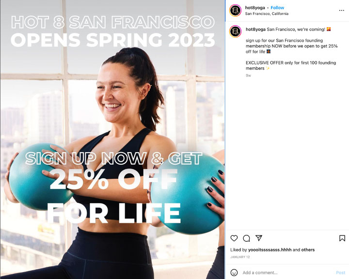 Woman smiling while holding exercise balls, promoting Hot 8 Yoga’s opening with a 25% off lifetime offer.