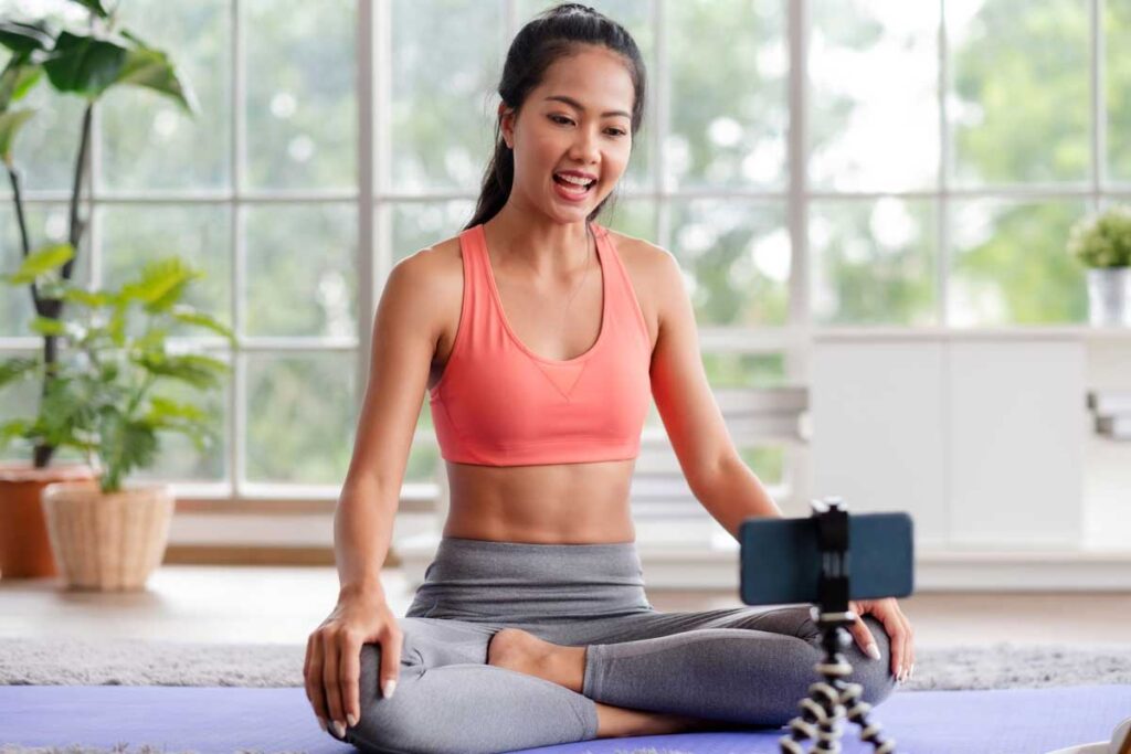 asian trainer woman live streaming on social media about wellness exercise at home