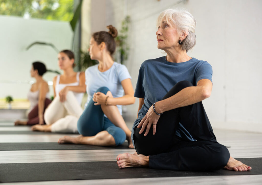 Group of sporty people practicing various yoga positions during training.