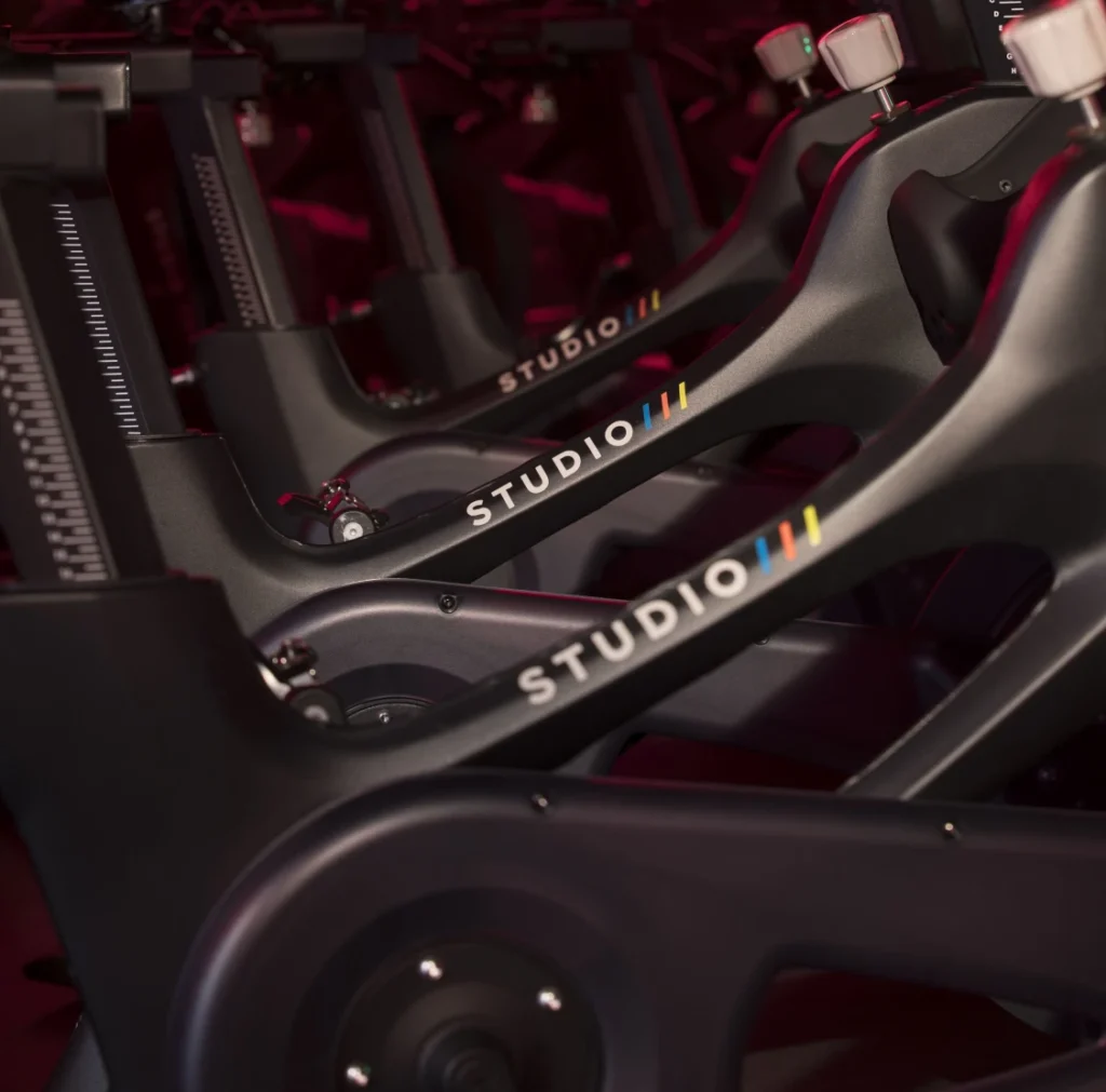 Close-up view of Studio Three branded stationary bikes in a fitness studio.