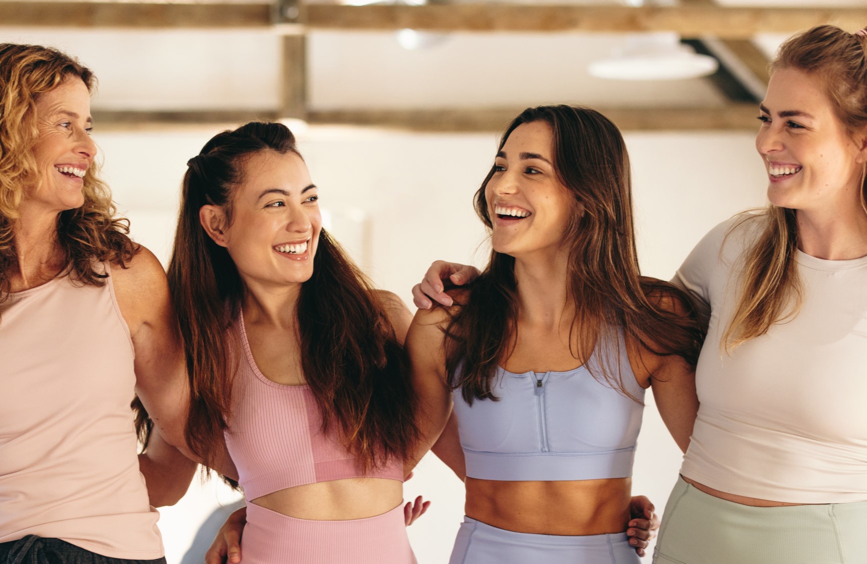 Four ladies smiling in gym wear in a studio